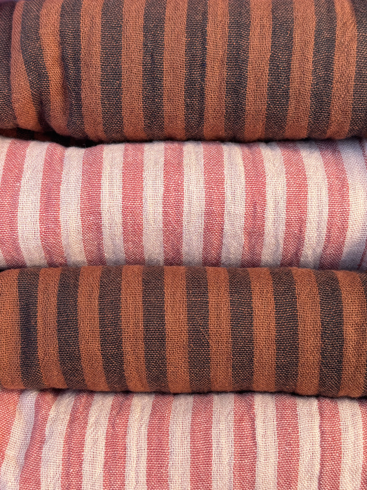 Quatre serviettes de table rayé skin et paprika pliées dans leur coffret