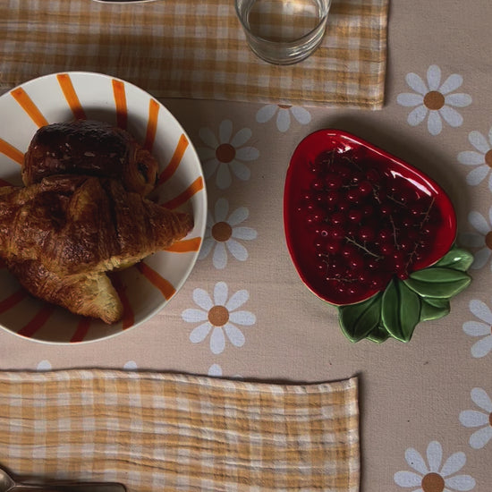 table de brunch avec des sets de tables en tissu jaune blé et une nappe orange pale à fleurs