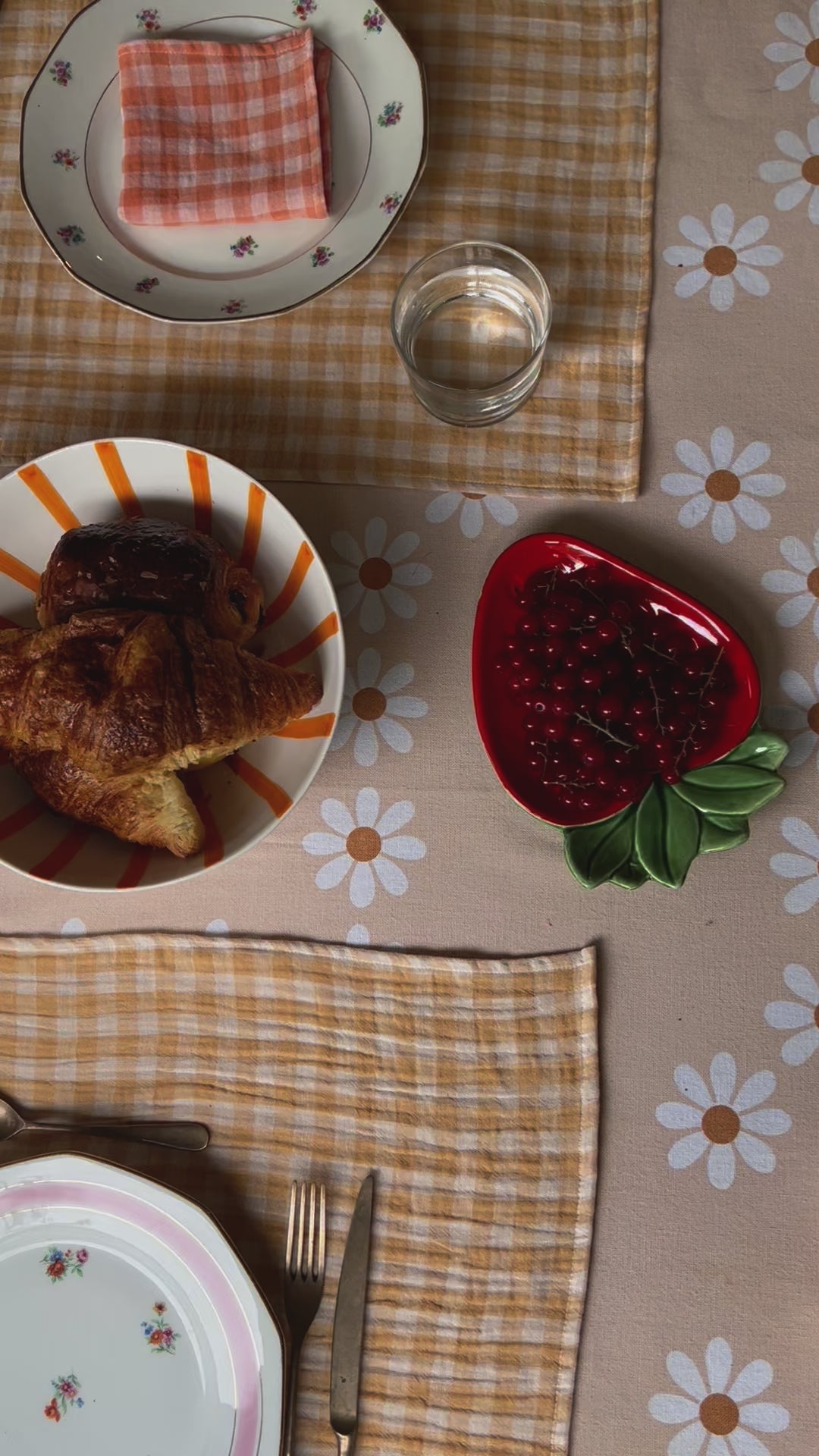 table de brunch avec des sets de tables en tissu jaune blé et une nappe orange pale à fleurs